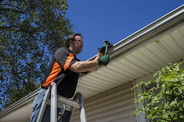 depositphotos_84767202-stock-photo-worker-repairing-a-gutter-on