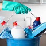 Woman holding cleaning products with glove.