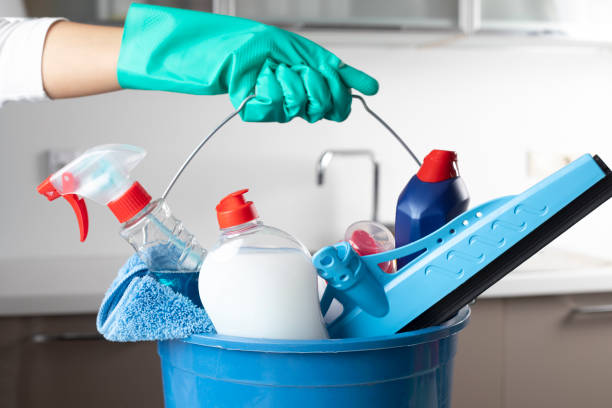 Woman holding cleaning products with glove.